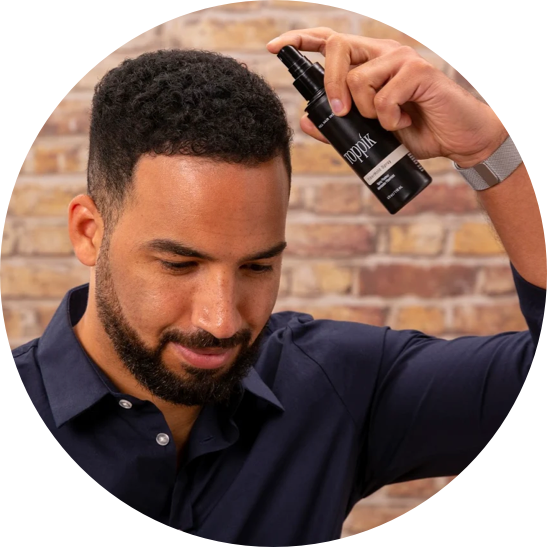 Male spraying product onto his hair